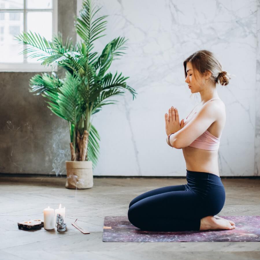 A woman sitting on her feet in a meditative yoga pose.