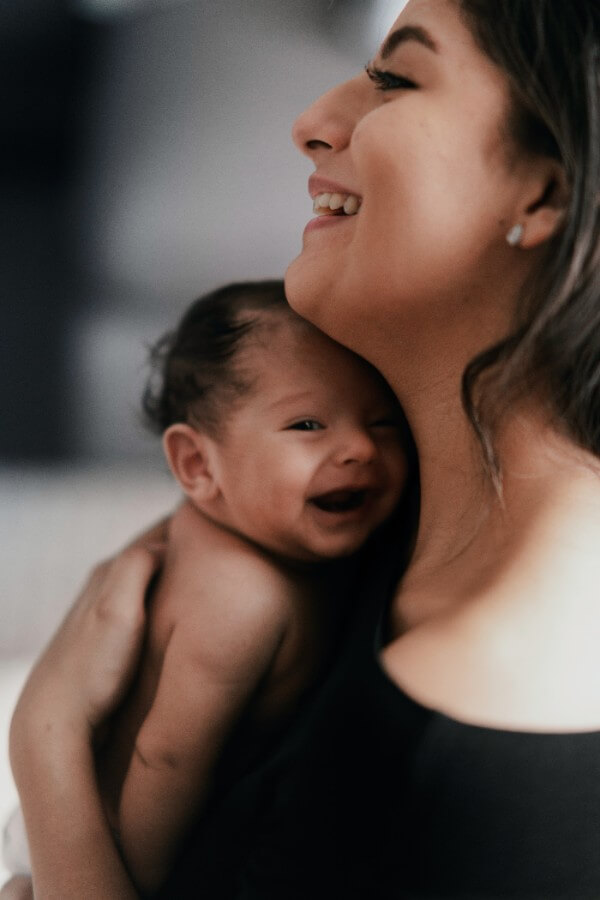 A mother smiling down at her infant.